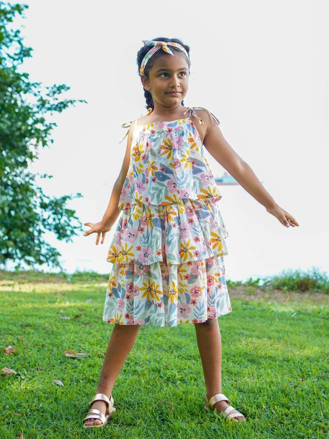 Girls tiered cotton dress in spring floral print with ruffled straps, sustainable and lightweight for casual wear.