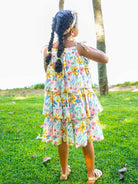 Girls tiered summer dress in vibrant spring floral print, lightweight sustainable cotton fabric, casual style.