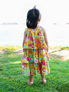 Girls tiered sundress in vibrant sunset bloom print, made from sustainable cotton, perfect for casual summer wear.