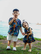 Toddler girl in sustainable cotton ocean mosaic playsuit with sleeveless design and gathered waist.